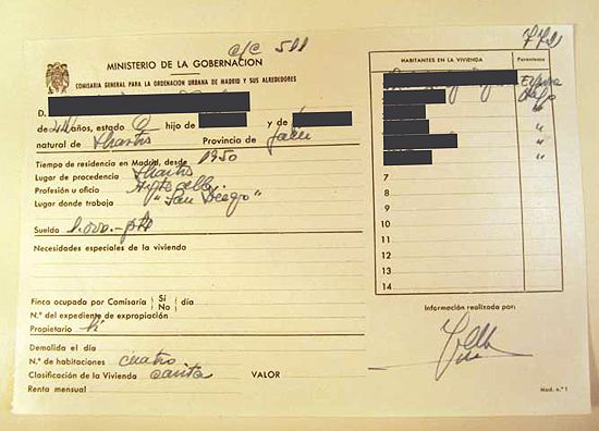 Las fichas elaboradas por el Ministerio de la Vivienda contaban con dos caras. En la anterior, junto con la fotografía familiar hecha en la puerta de la vivienda, se detallaba su ubicación, así como el número y nombre de sus habitantes. La cara posterior contenía los datos del cabeza de familia así como su tiempo de residencia en Madrid, localidad de procedencia, oficio, lugar de trabajo y sueldo. La ficha de la fotografía corresponde a una “chabola” situada en El Pozo del Tío Raimundo y en ella aparecen retratados sus siete habitantes —el matrimonio y sus cinco hijos—. La profesión del cabeza de familia era ayudante de albañil y cobraba un sueldo de 1.000 pesetas mensuales, equivalentes a 6 euros de la actualidad. Se detalla igualmente que los habitantes son propietarios de la vivienda. La imagen es del 18 de agosto de 1956.(© Foto: JJMANCHA / Vallecasweb.com) Las fichas elaboradas por el Ministerio de la Vivienda contaban con dos caras. En la anterior, junto con la fotografía familiar hecha en la puerta de la vivienda, se detallaba su ubicación, así como el número y nombre de sus habitantes. La cara posterior contenía los datos del cabeza de familia así como su tiempo de residencia en Madrid, localidad de procedencia, oficio, lugar de trabajo y sueldo. La ficha de la fotografía corresponde a una “chabola” situada en El Pozo del Tío Raimundo y en ella aparecen retratados sus siete habitantes —el matrimonio y sus cinco hijos—. La profesión del cabeza de familia era ayudante de albañil y cobraba un sueldo de 1.000 pesetas mensuales, equivalentes a 6 euros de la actualidad. Se detalla igualmente que los habitantes son propietarios de la vivienda. La imagen es del 18 de agosto de 1956.(© Foto: JJMANCHA / Vallecasweb.com)