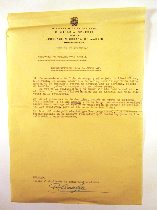 El Servicio de Información Social de la Comisaría General para la Ordenación Urbana de Madrid proveía al fotógrafo de unas instrucciones que debía seguir a rajatabla. Entre ellas, se detallaba la obligación de fotografiar la fachada o puerta de entrada a la “cueva, chabola o inmueble” y “al pie de la edificación y en lugar bien visible deberá colocar el número de orden de filiación para que se aprecie con toda nitidez en la fotografía”. (© Foto: JJMANCHA / Vallecasweb.com) El Servicio de Información Social de la Comisaría General para la Ordenación Urbana de Madrid proveía al fotógrafo de unas instrucciones que debía seguir a rajatabla. Entre ellas, se detallaba la obligación de fotografiar la fachada o puerta de entrada a la “cueva, chabola o inmueble” y “al pie de la edificación y en lugar bien visible deberá colocar el número de orden de filiación para que se aprecie con toda nitidez en la fotografía”. (© Foto: JJMANCHA / Vallecasweb.com)