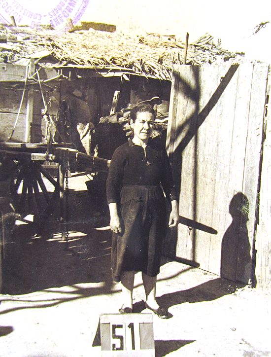 El tiempo ha permitido que las imágenes destinadas a identificar a los habitantes con sus viviendas, dejen al descubierto otros detalles de gran valor. Por ejemplo, la foto de esta vecina tomada frente a una chabola del Barrio de la Celsa, permite ver tras ella un carro de madera destinado al tiro de animales. (© Foto: JJMANCHA / Vallecasweb.com) El tiempo ha permitido que las imágenes destinadas a identificar a los habitantes con sus viviendas, dejen al descubierto otros detalles de gran valor. Por ejemplo, la foto de esta vecina tomada frente a una chabola del Barrio de la Celsa, permite ver tras ella un carro de madera destinado al tiro de animales. (© Foto: JJMANCHA / Vallecasweb.com)