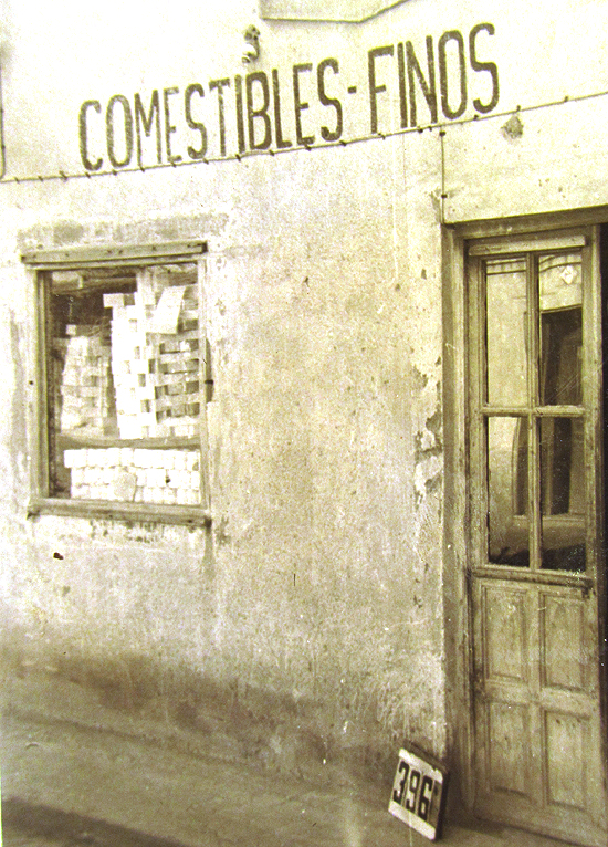 Las tiendas de comestibles triunfaron en barrios en los que había muchas bocas —en su mayoría de niños— que alimentar. La de la imagen muestra latas de conservas en su diminuto escaparate y un rótulo totalmente sugerente: “Comestibles finos”. Estaba ubicada en la calle Sepúlveda nº 11 de Entrevías. (© Foto: JJMANCHA / Vallecasweb.com) Las tiendas de comestibles triunfaron en barrios en los que había muchas bocas —en su mayoría de niños— que alimentar. La de la imagen muestra latas de conservas en su diminuto escaparate y un rótulo totalmente sugerente: “Comestibles finos”. Estaba ubicada en la calle Sepúlveda nº 11 de Entrevías. (© Foto: JJMANCHA / Vallecasweb.com)